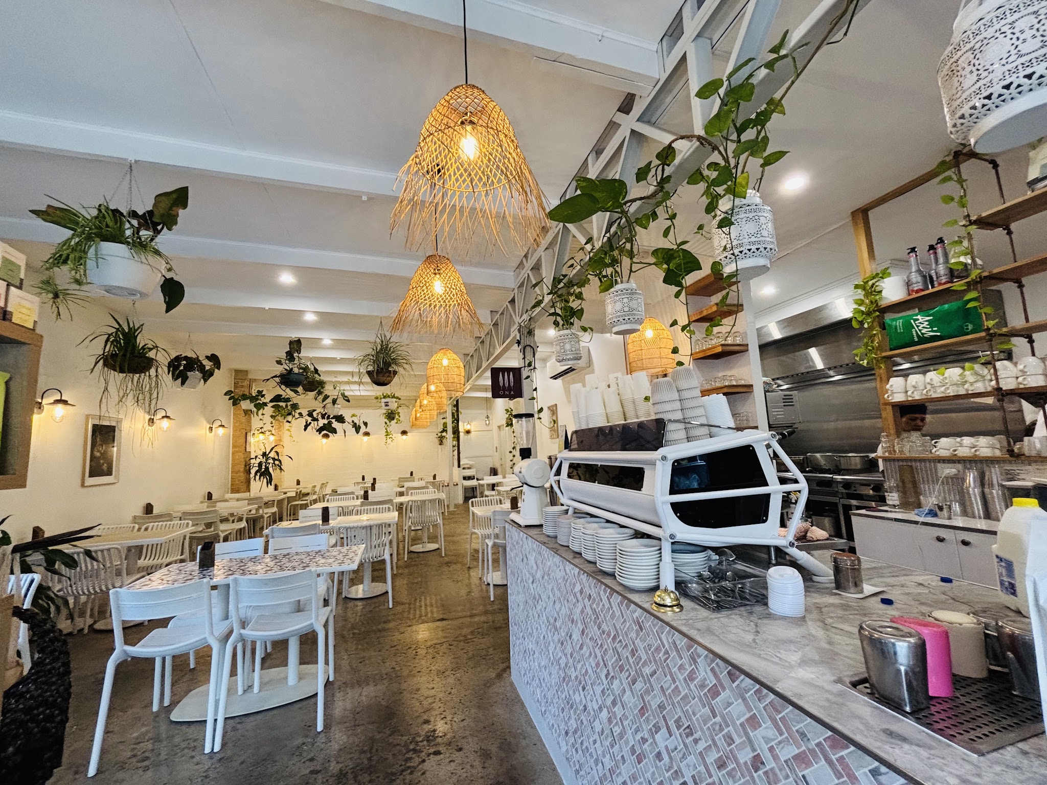 A wide view across the dining room to the tiled counter and espresso machine