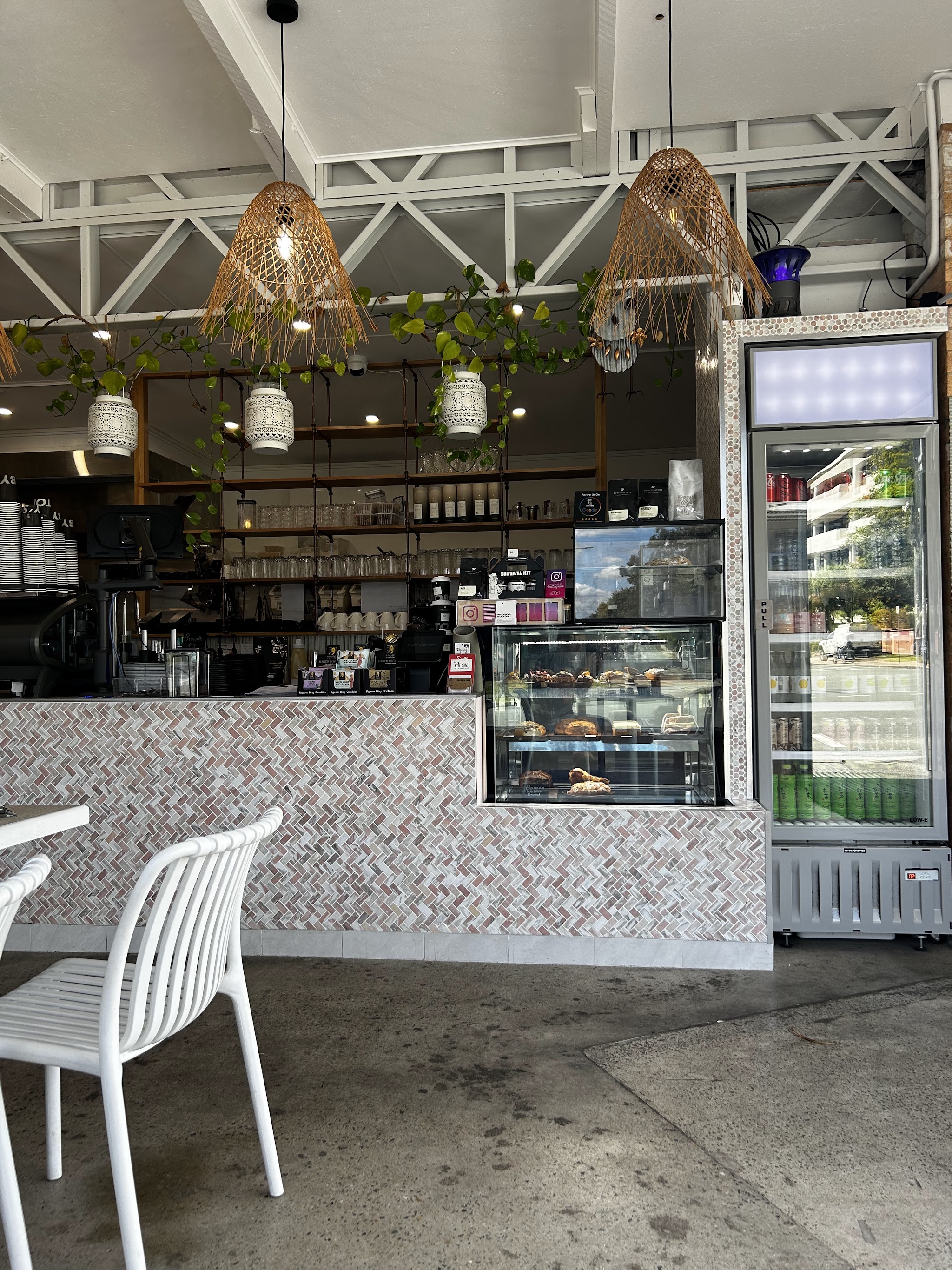 The counter with its pastry cabinet of baked goods and a drinks fridge